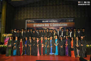 Graduates in caps and gowns pose on stage at RCM Global School's convocation ceremony.