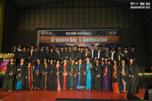 Graduates in caps and gowns on stage at RCM Global School's "Graduate Day & Convocation" event.