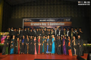 Individuals in graduation attire on stage at RCM Global B-School Graduation Day 2K25.