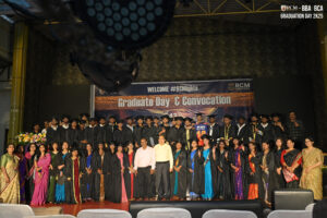 RCM Global School Graduation Ceremony Graduates on stage at RCM Global School's convocation, wearing caps, gowns, and traditional attire.