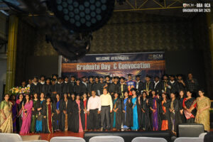 Graduates and faculty on stage during RCM Global School's indoor convocation ceremony.