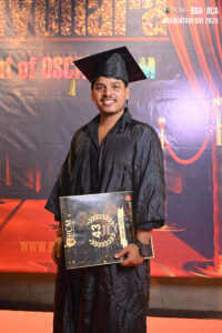 Person in black graduation attire holding certificate, with "Graduation Day 2K25" banner.