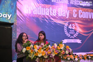 Individuals on stage at "Graduate Day," celebrating 43 years since 1982, with floral decor.