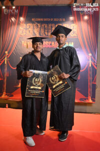 Two graduates stand on red carpet with certificates at RCM Global B-School 2022-25 event.