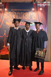 Graduates in gowns holding diplomas at RCM Global B School's 2K25 event backdrop.