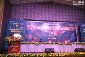 Graduation ceremony at Regional College of Management with banners and people in regalia.