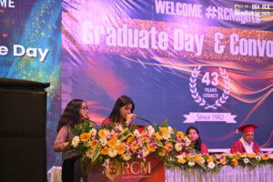 Graduation ceremony at Regional College of Management with speakers and participants on stage.