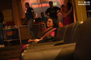 Woman in auditorium during RCM BBA, BCA 2025 graduation, "Night of OSCARS" event backdrop.