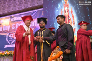 Graduates in gowns light candles at a ceremony, celebrating Graduation Day 2K25 and a 43-year legacy.