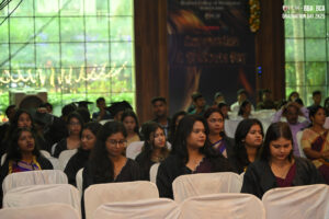 Individuals in graduation attire at a formal event, with a "Graduation Day 2K25" banner.