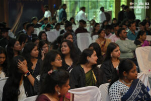 People seated indoors for a formal BBA and BCA graduation ceremony, facing forward.