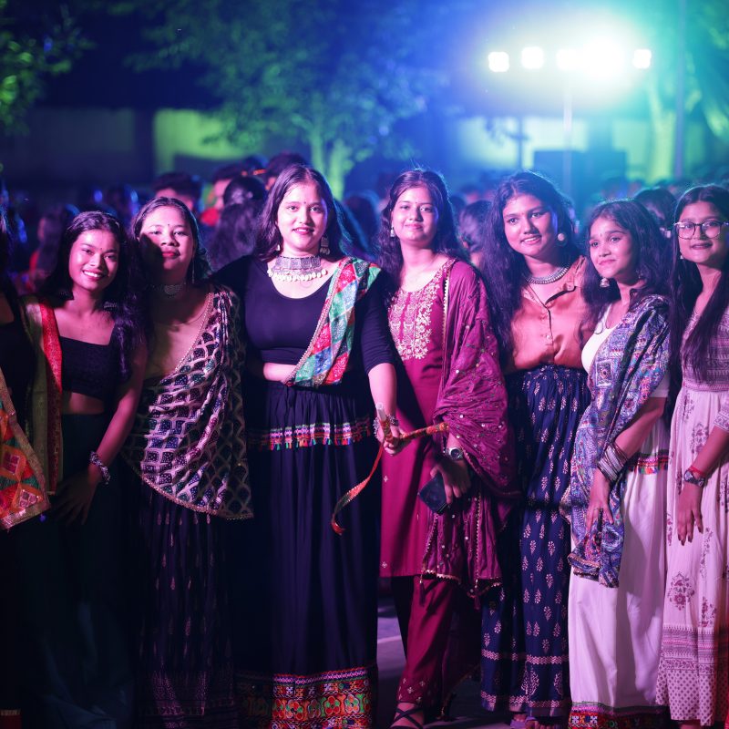Students enjoying Mega Dandiya Night 2024 with music, dance, traditional attire, and vibrant decorations.
