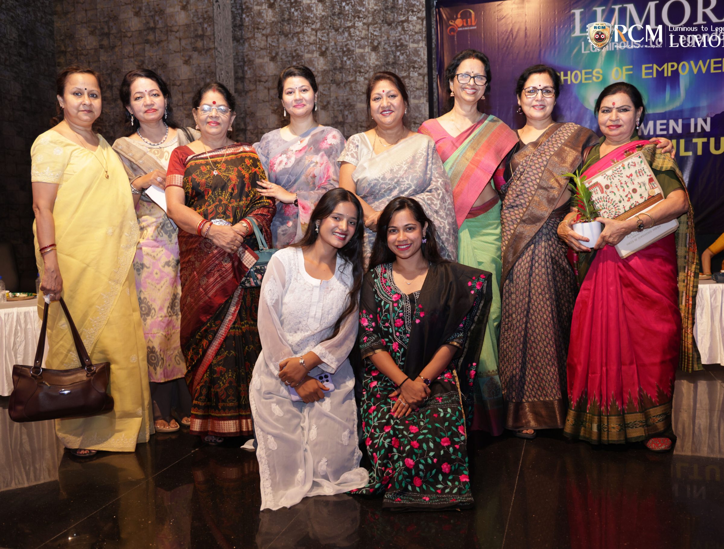 Guests posing for a group picture at Lumora event
