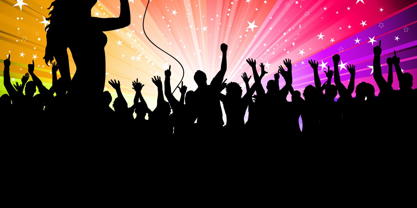 Silhouette of a female singer performing in front of a cheering audience